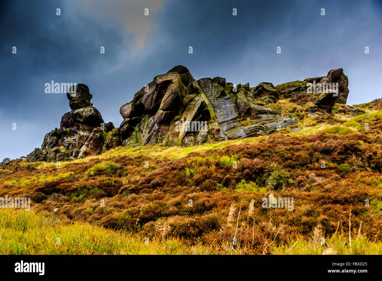 A rocky outcrop with dark, threatening sky in the Staffordshire Peak District, Staffordshire, England, UK Stock Photo