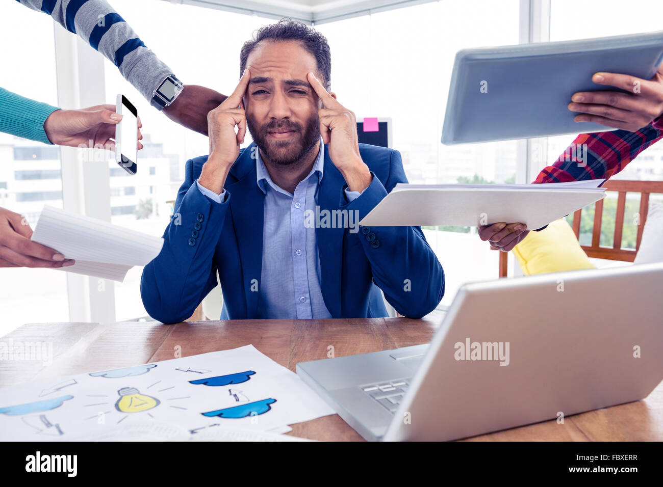 Stressful businessman by colleagues in creative office Stock Photo