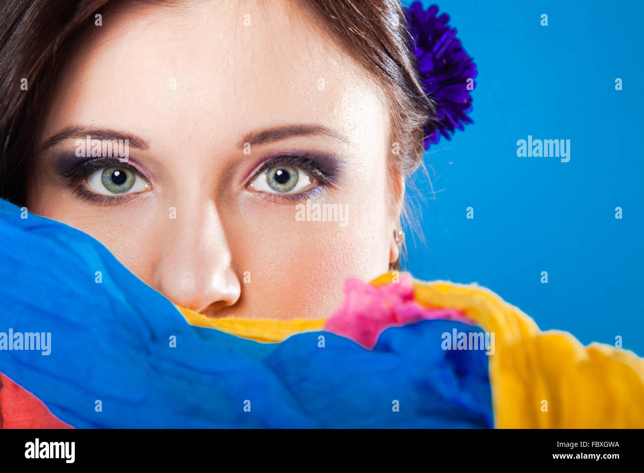 woman hides her face with shawl on blue Stock Photo - Alamy