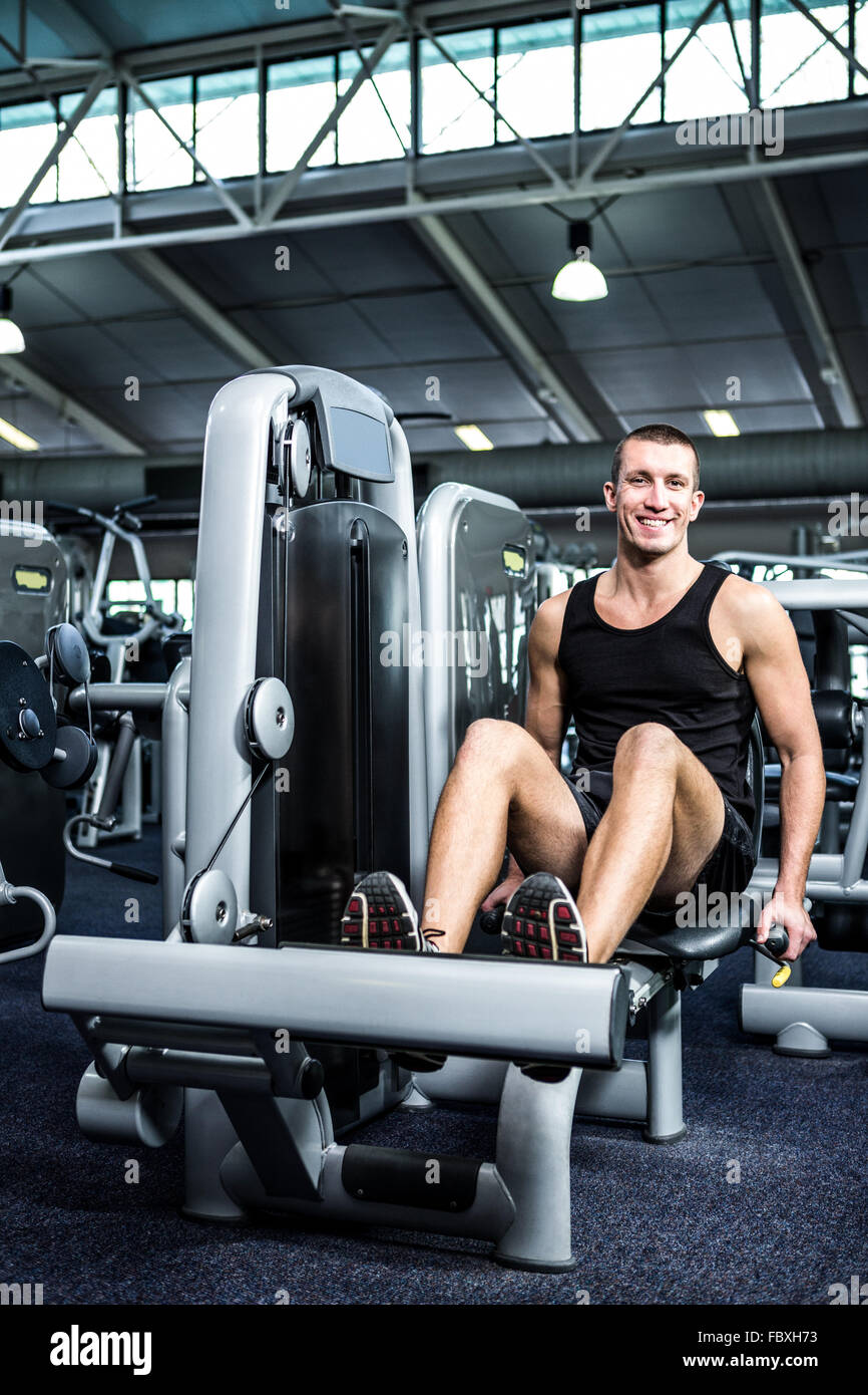 Muscular man using exercise machine for legs Stock Photo