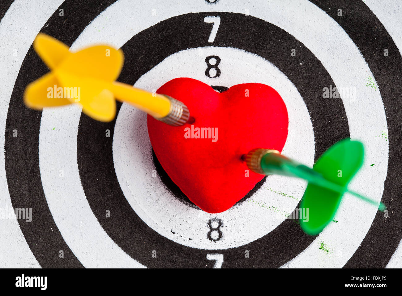 Black white target with two darts in heart love symbol as bullseye Stock Photo