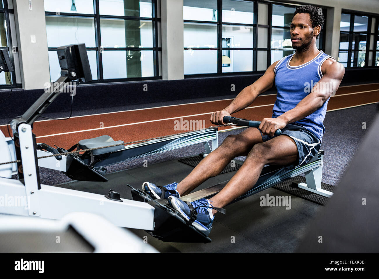 Muscular man using rowing machine Stock Photo