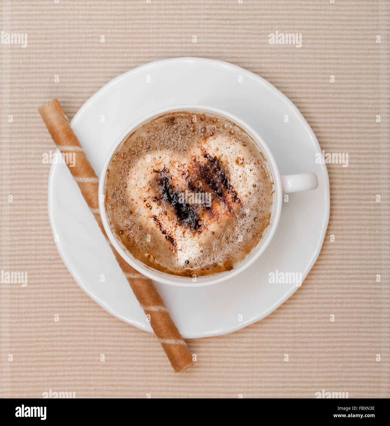 White cup coffe and waffle roll with cream on brown background Stock Photo