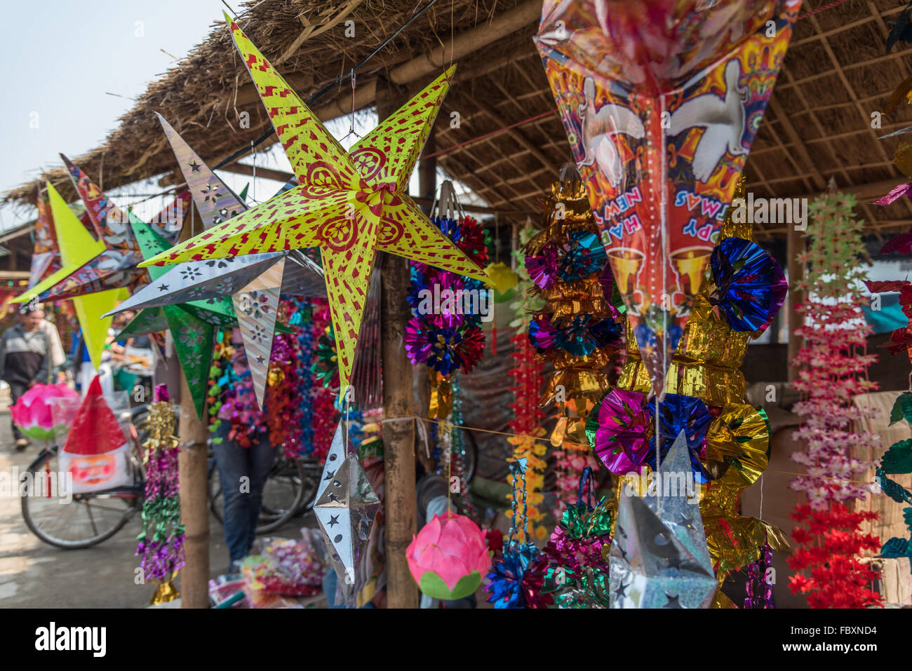 Indian market. Vibrant paper and foil Christmas decorations and stars available to buy at the Balipara Saturday Market,  Assam, India. Stock Photo