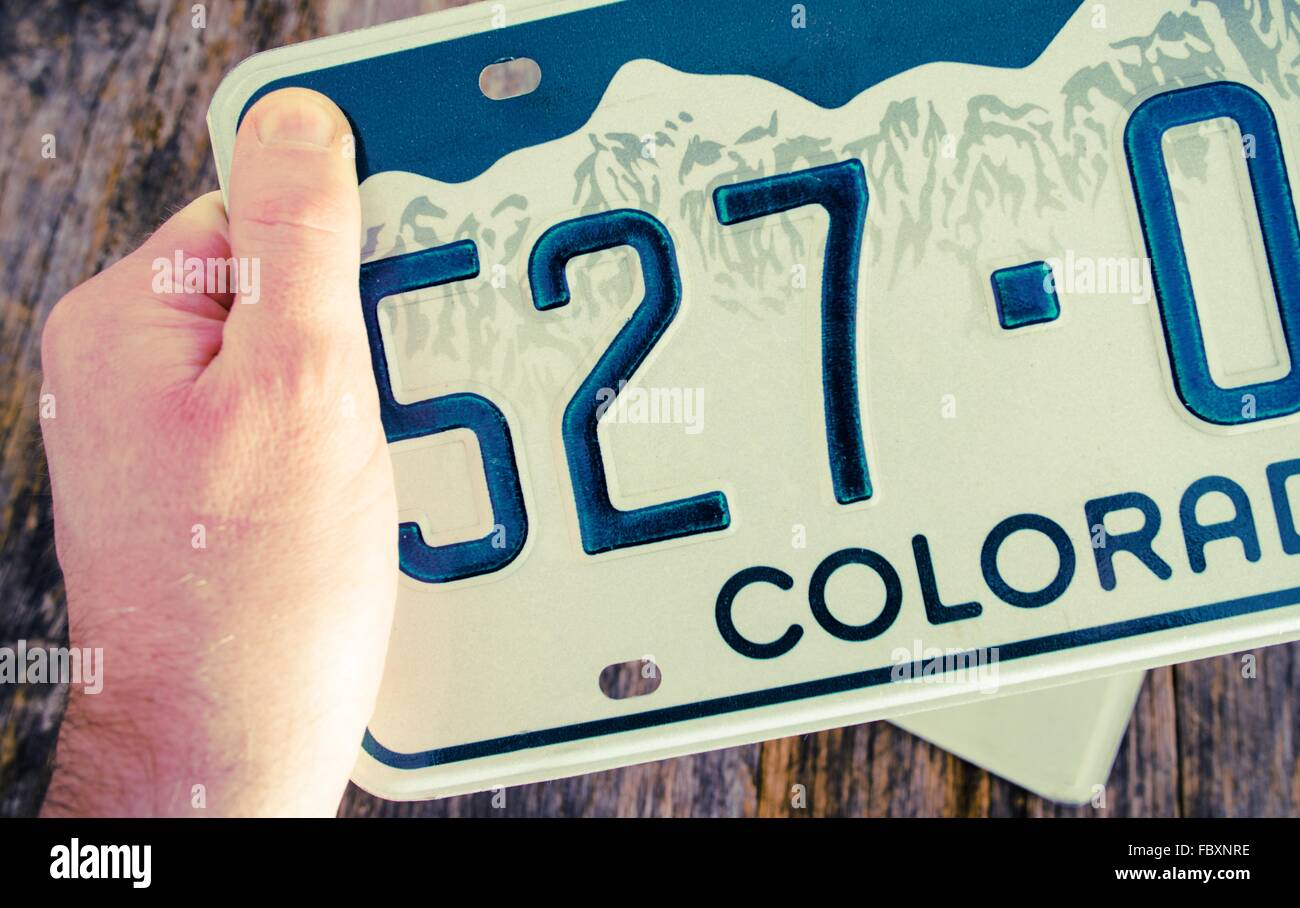 Colorado License Plate in Hand Closeup Photo. Colorado Vehicle