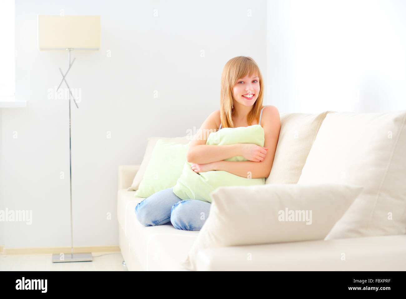 smiling girl sitting on sofa Stock Photo - Alamy