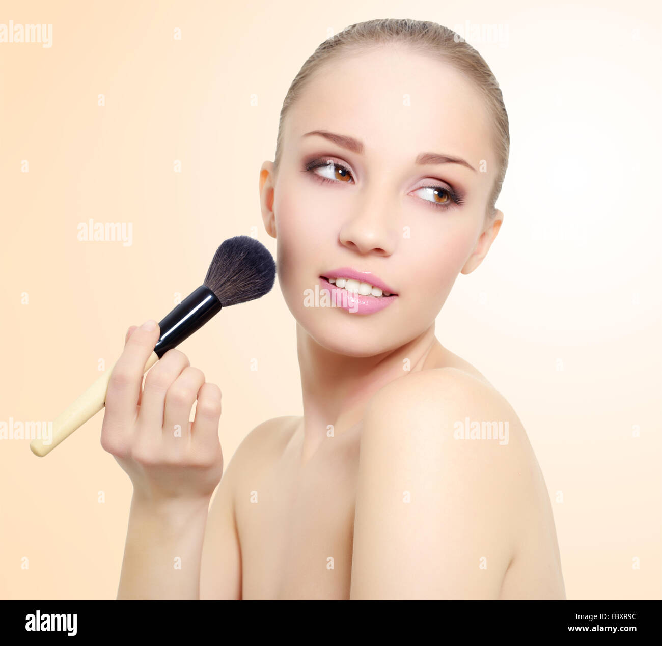 Portrait of girl with make-up brush Stock Photo
