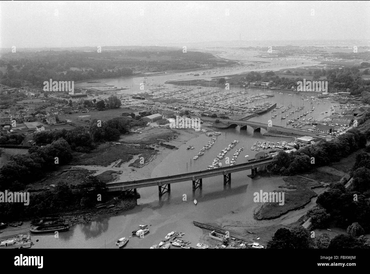 AJAXNETPHOTO. 1979. BURSLEDON, ENGLAND. - YACHTING MECCA - AERIAL VIEW OF THE FAMOUS HAMBLE RIVER WINDING SOUTH WEST TOWARD SOUTHAMPTON WATER AND THE SOLENT. FOREGROUND IS THE BURSLEDON RAILWAY RIVER CROSSING VIADUCT WITH A27 ROAD BRIDGE CENTRE RIGHT.  PHOTO:JONATHAN EASTLAND/AJAX  REF:12064 Stock Photo
