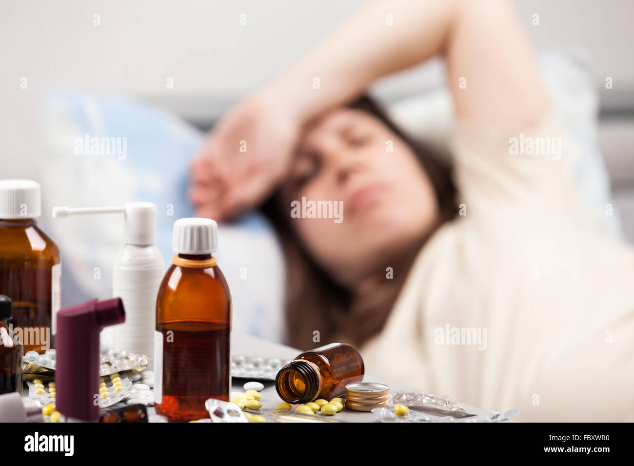 Unwell woman patient lying down bed Stock Photo