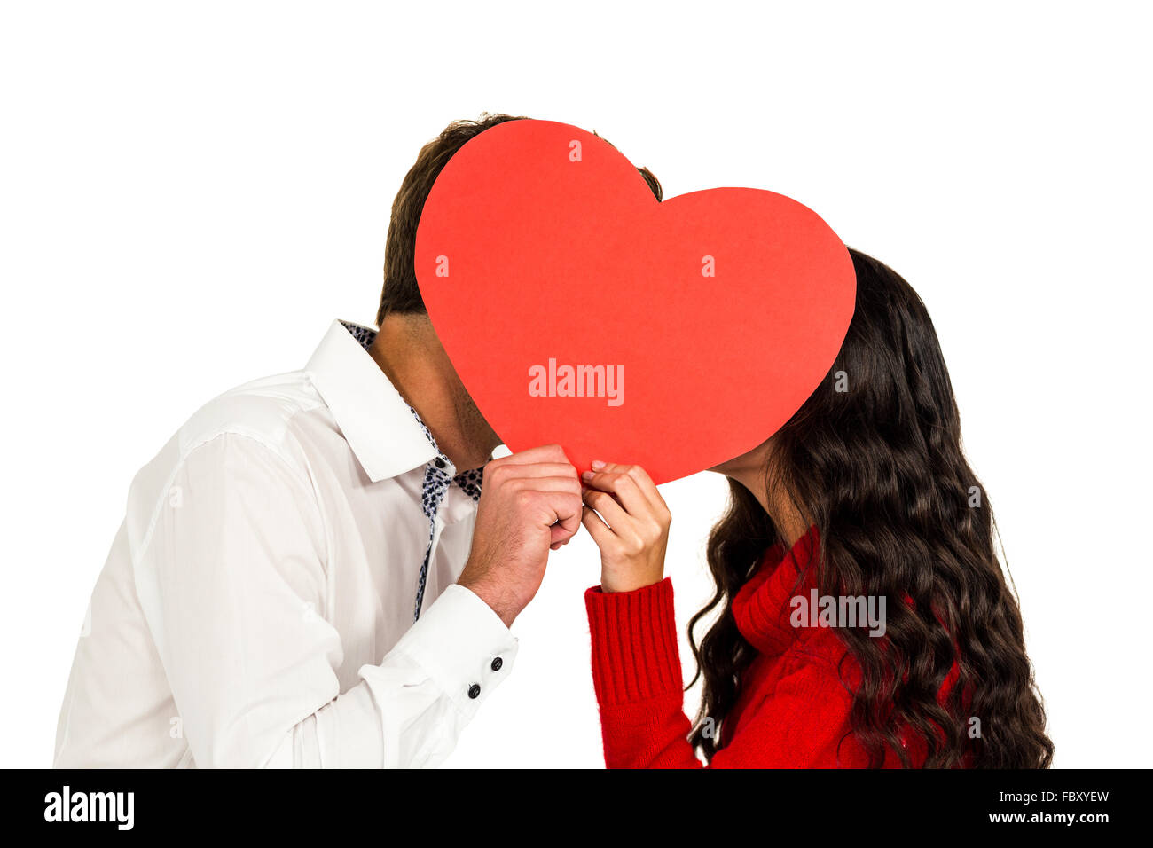Couple covering faces with paper heart Stock Photo