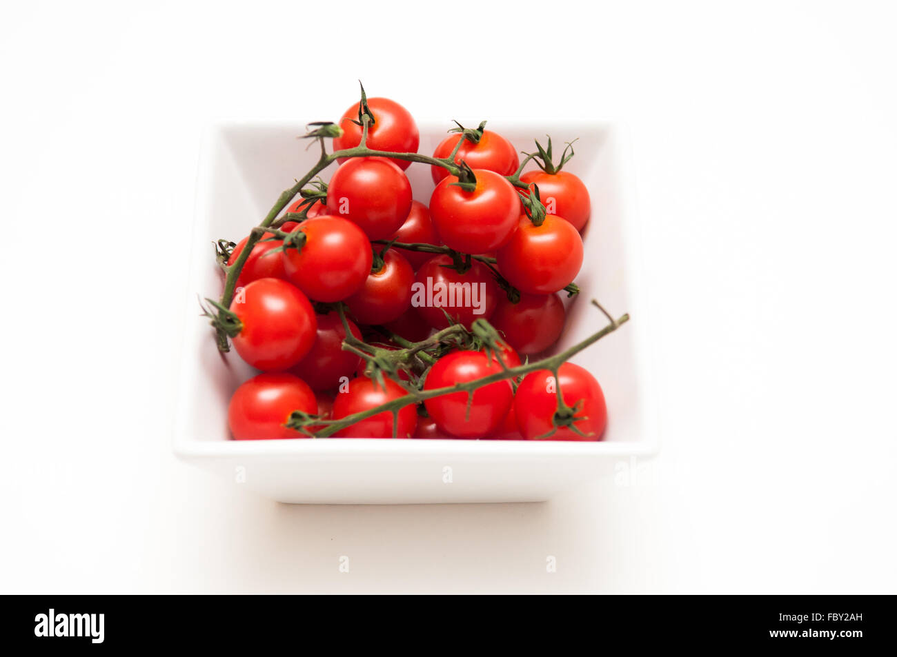 Ripe vine tomatoes on a white background Stock Photo - Alamy