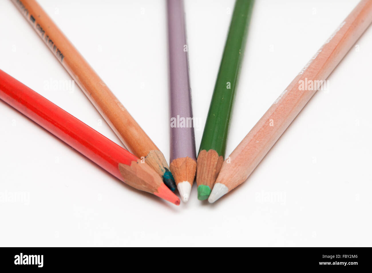 Five coloured pencils arranged on a white background Stock Photo