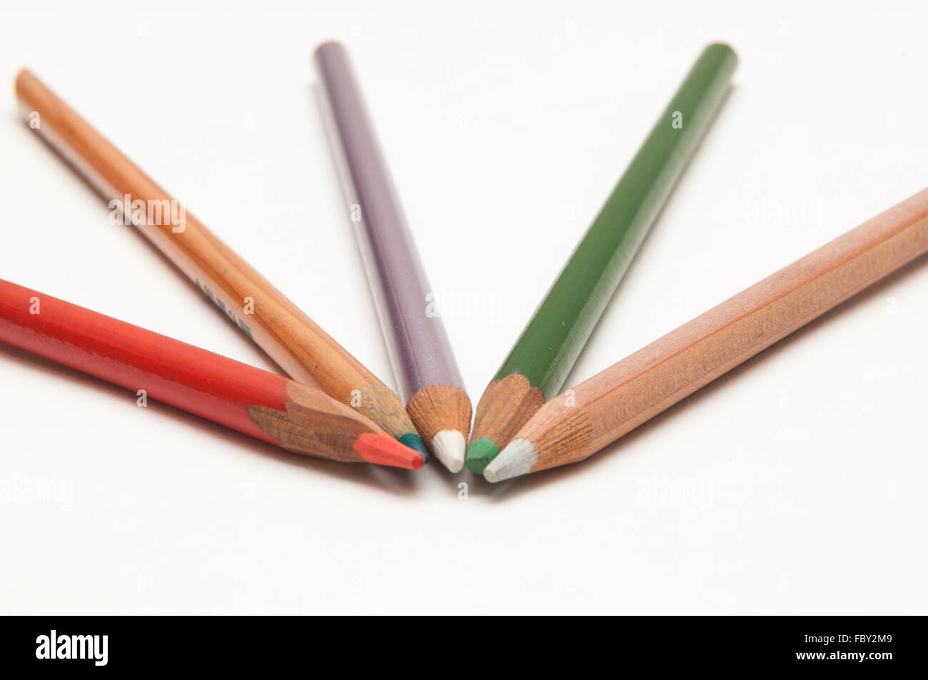Five coloured pencils arranged on a white background Stock Photo