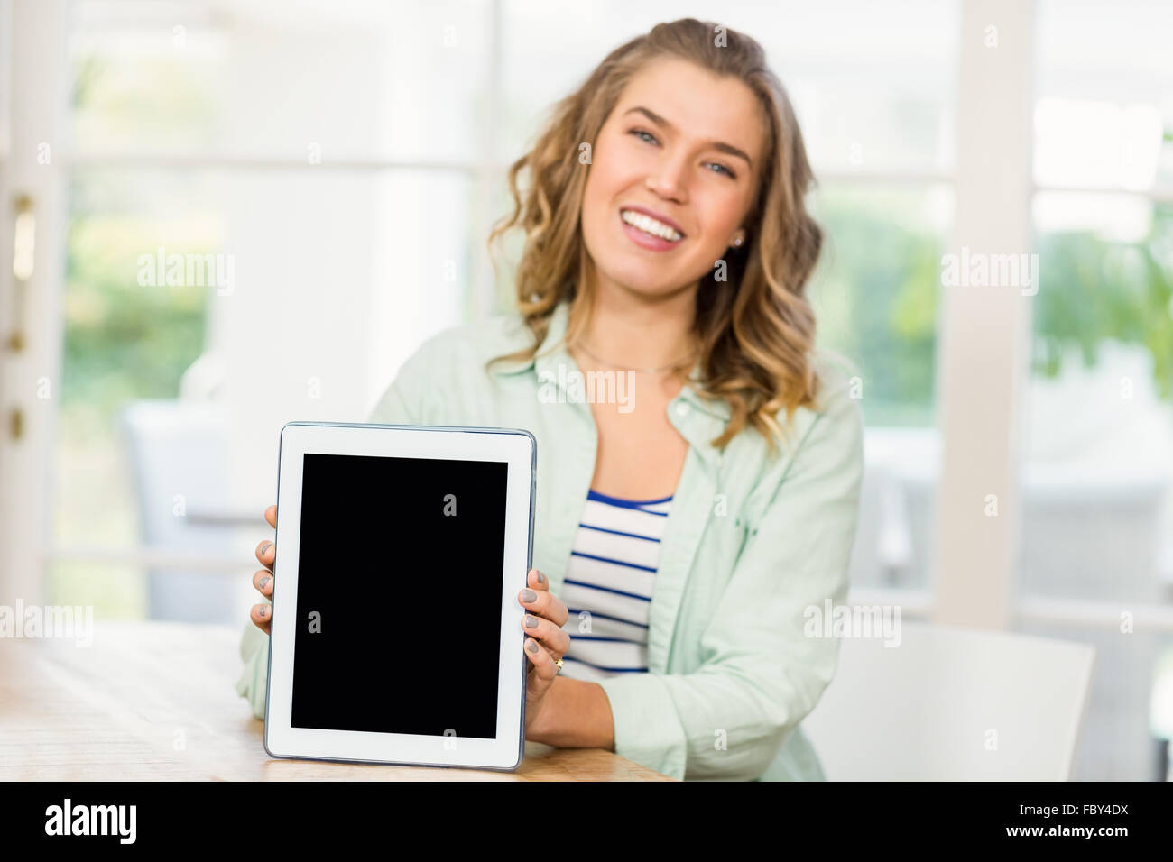 Blonde woman showing tablet screen Stock Photo