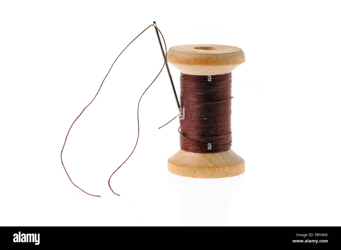 Black Thread on an Old Wooden Spool and Sewing Needle Stock