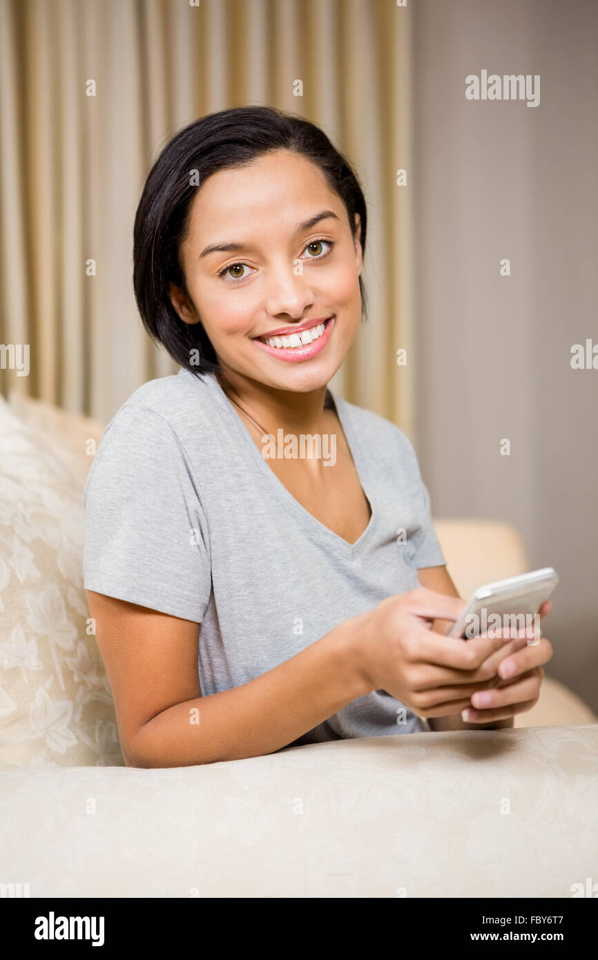 Smiling brunette using smartphone Stock Photo