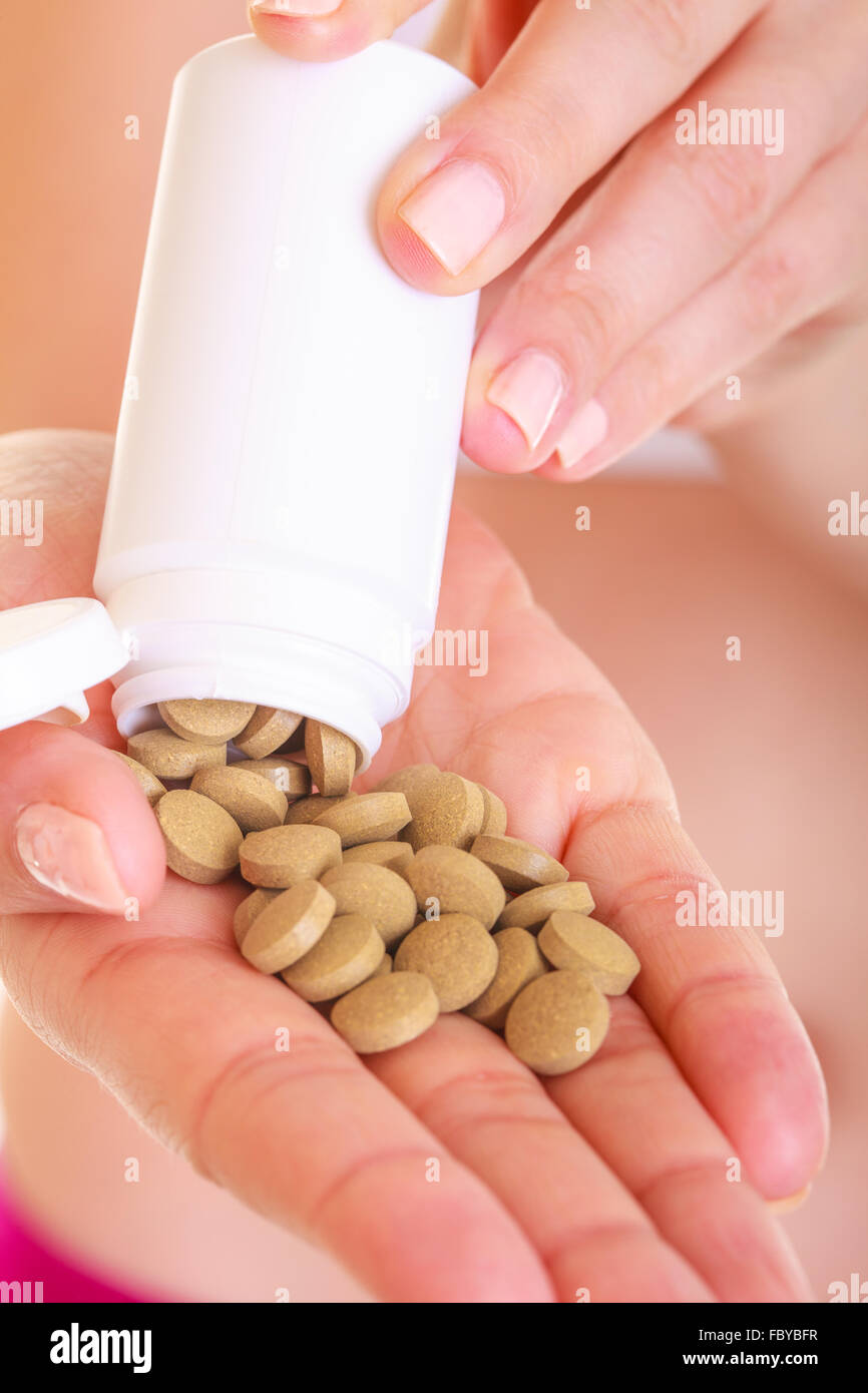 Close up woman hand holding bottle of prescription medicine drug pills. Dietary supplement Stock Photo