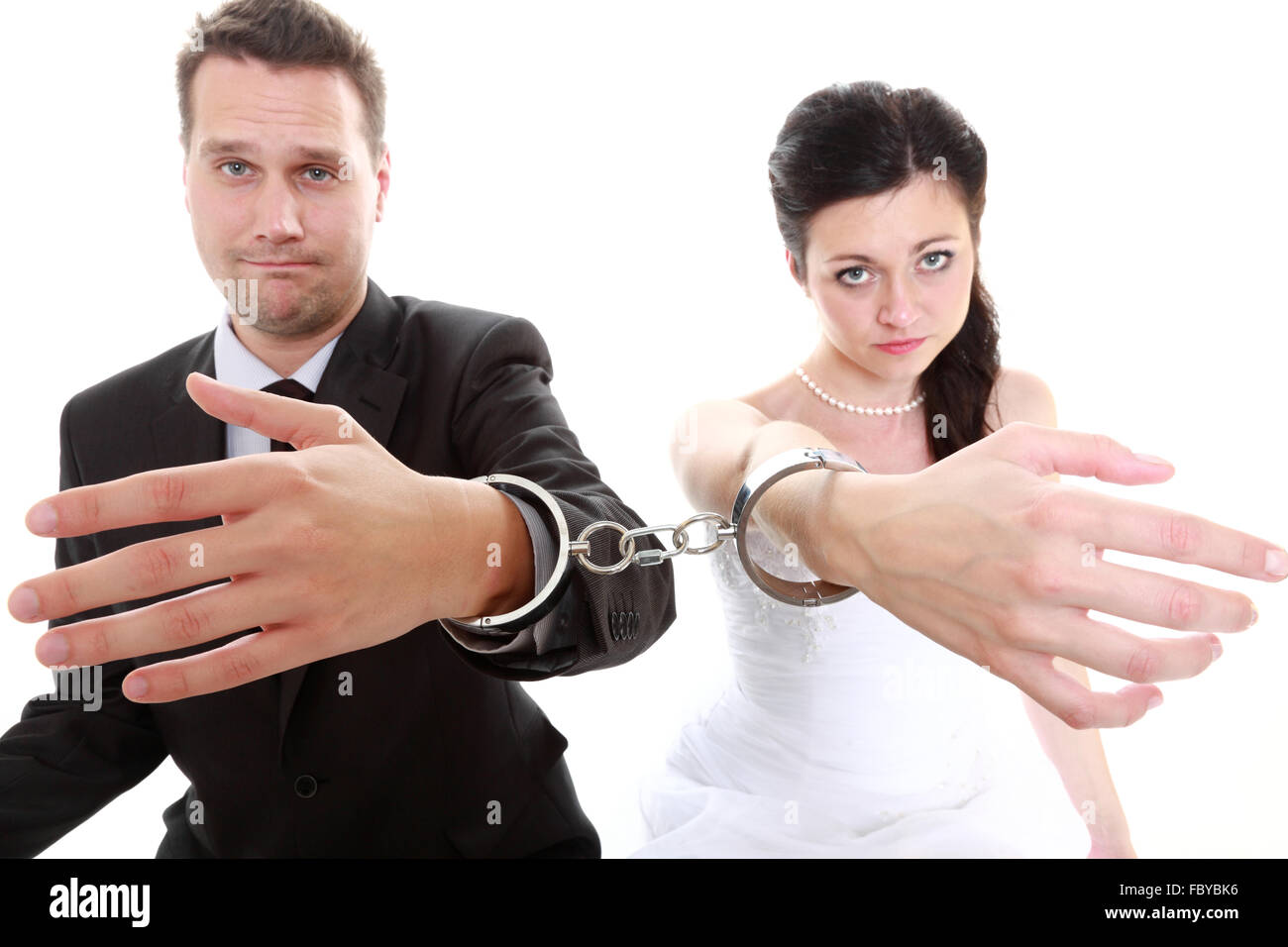Break up ending relationship between husband and wife. Couple in divorce crisis. Man woman unhappy holding hands in handcuffs. I Stock Photo