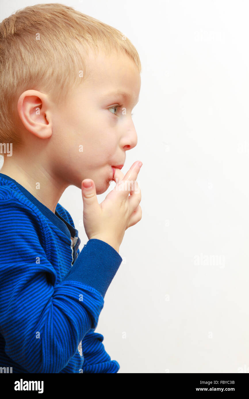 Portrait of cute boy child kid preschooler licking his fingers Stock Photo