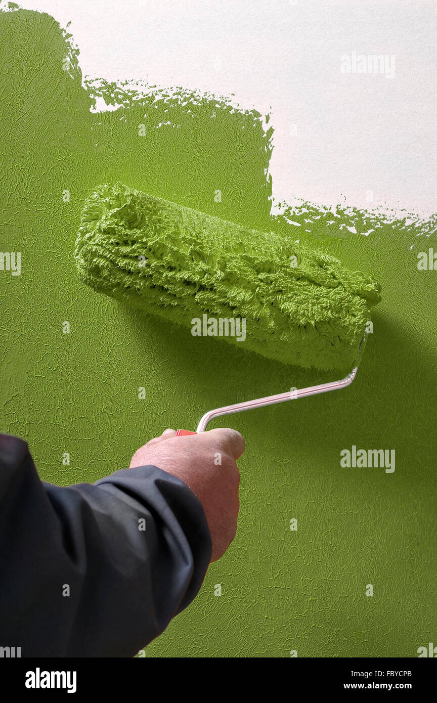 White facades painting with paint roller - hand applying Stock Photo