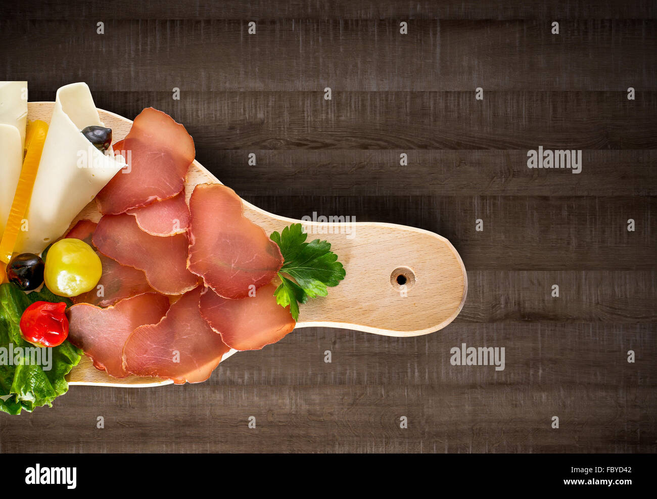 Prosciutto - parma smoked ham with vegetables on wooden board and clipping path Stock Photo