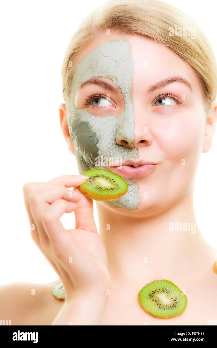 Skin care. Woman in clay mask with kiwi on face Stock Photo
