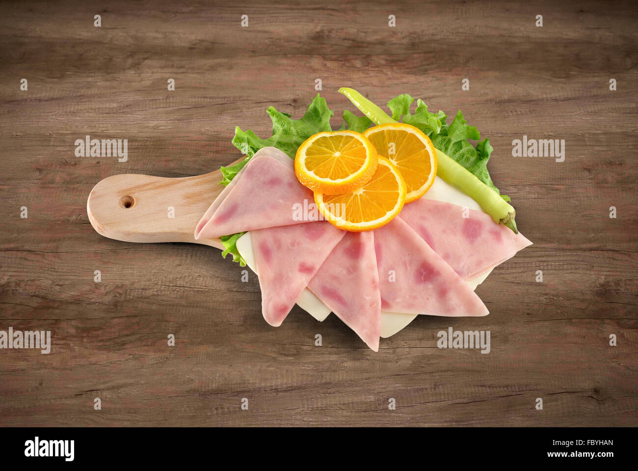 Pizza ham sliced on wooden board with clipping path Stock Photo