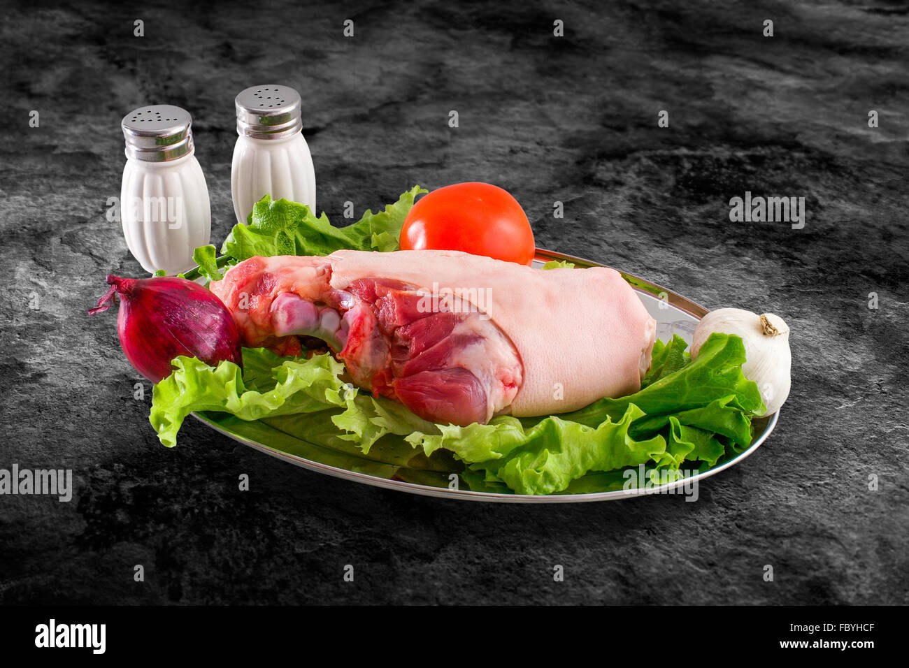 Fresh raw pork Hindleg foot decorated with vegetables and clipping path Stock Photo