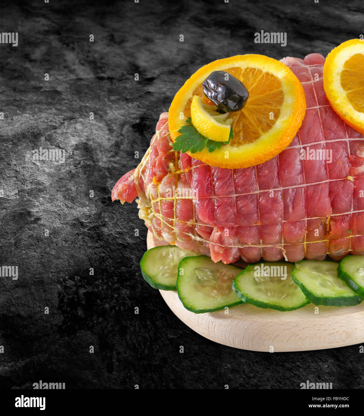 Rolled fresh ham meat in tied - veal roulade. Raw rolled meat enclosed in net netting with spices - ready to barbecue-bbq and cl Stock Photo
