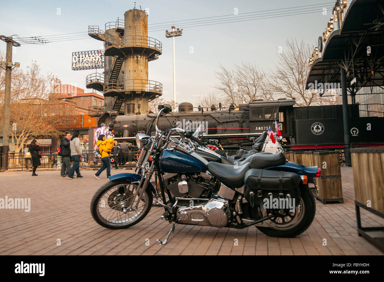 A collection of motorbikes in front of 0751 steam locomotive outside ACE Cafe, Beijing China seen in winter Stock Photo