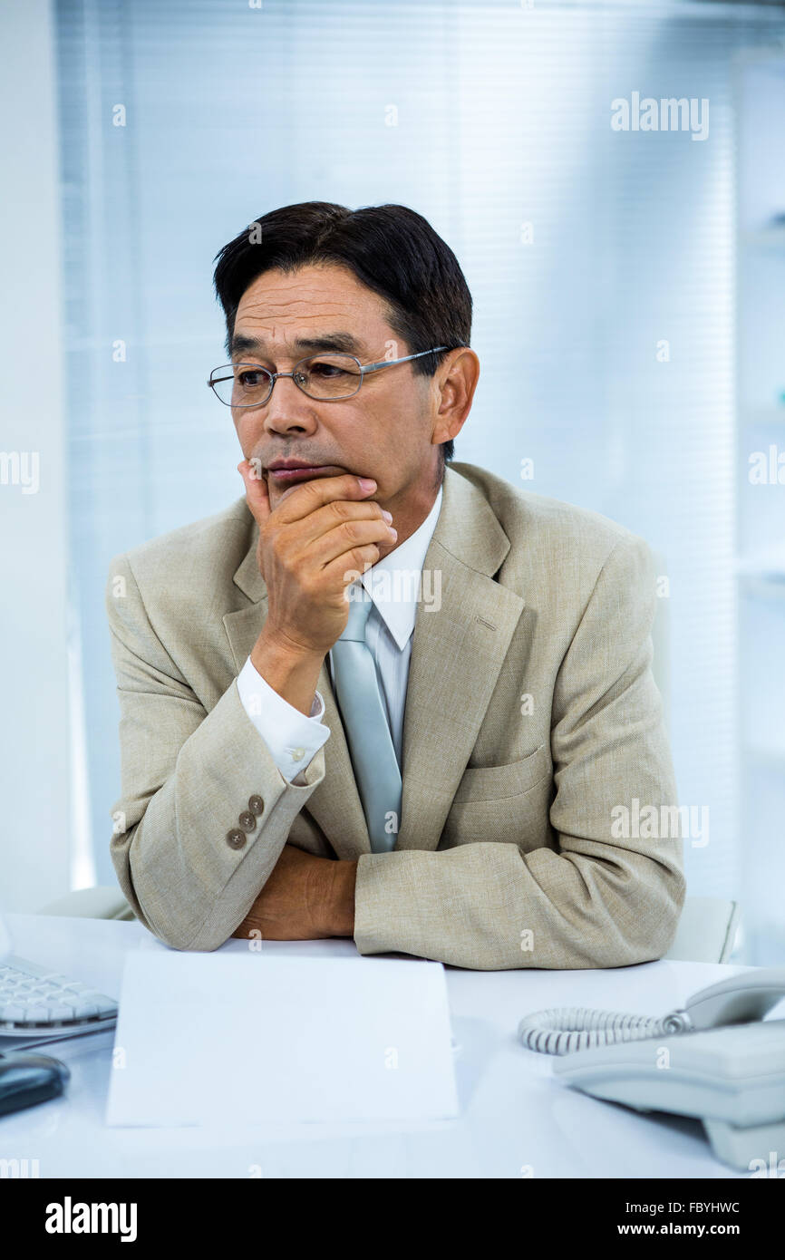 Undecided businessman at his computer Stock Photo