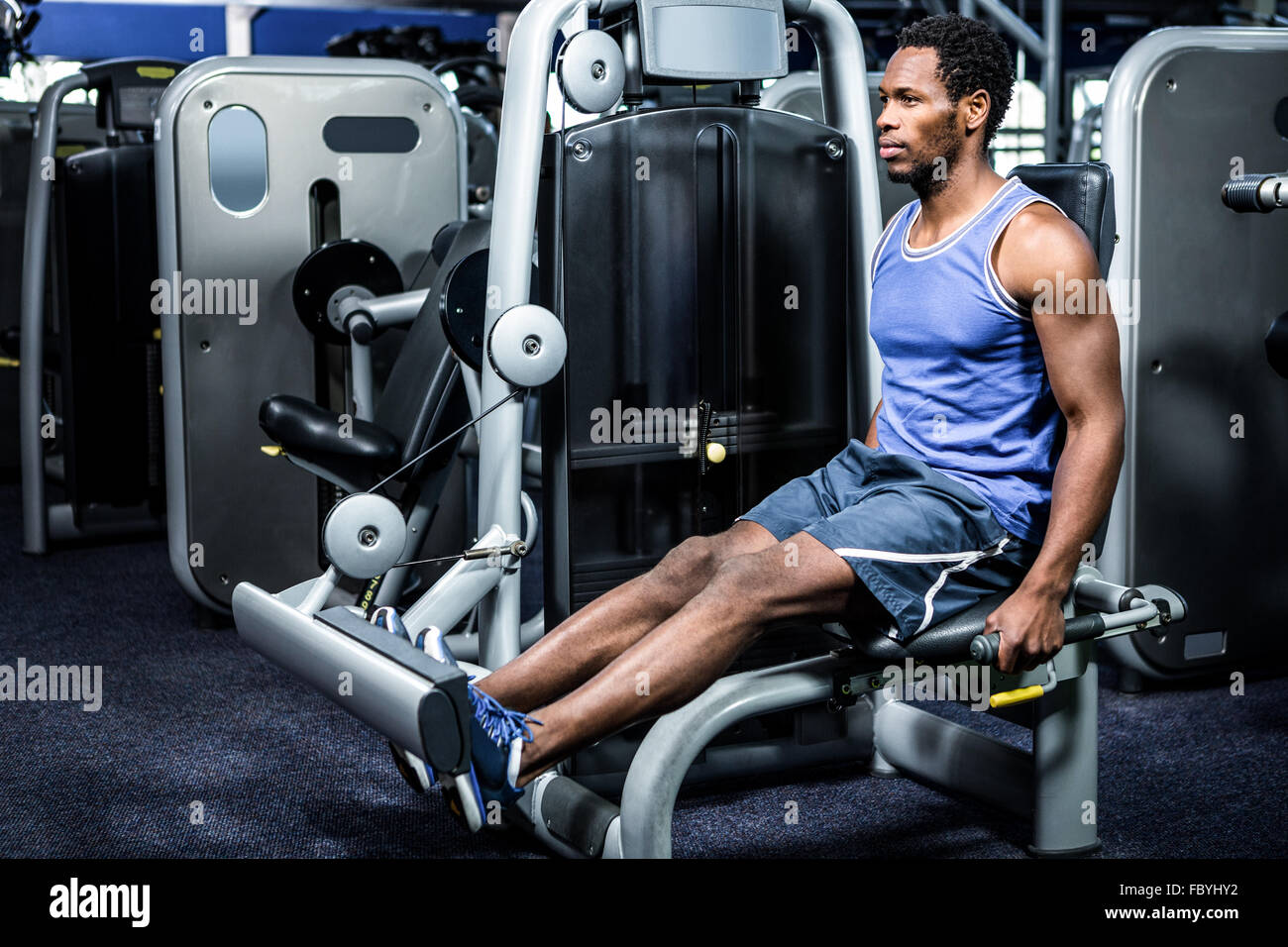 Serious muscular man using exercise machine Stock Photo