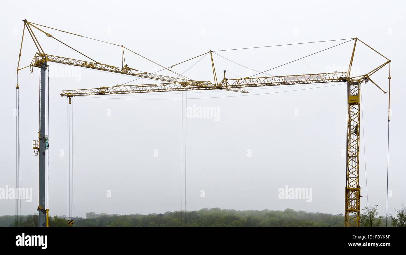 two tower cranes on a dim day Stock Photo