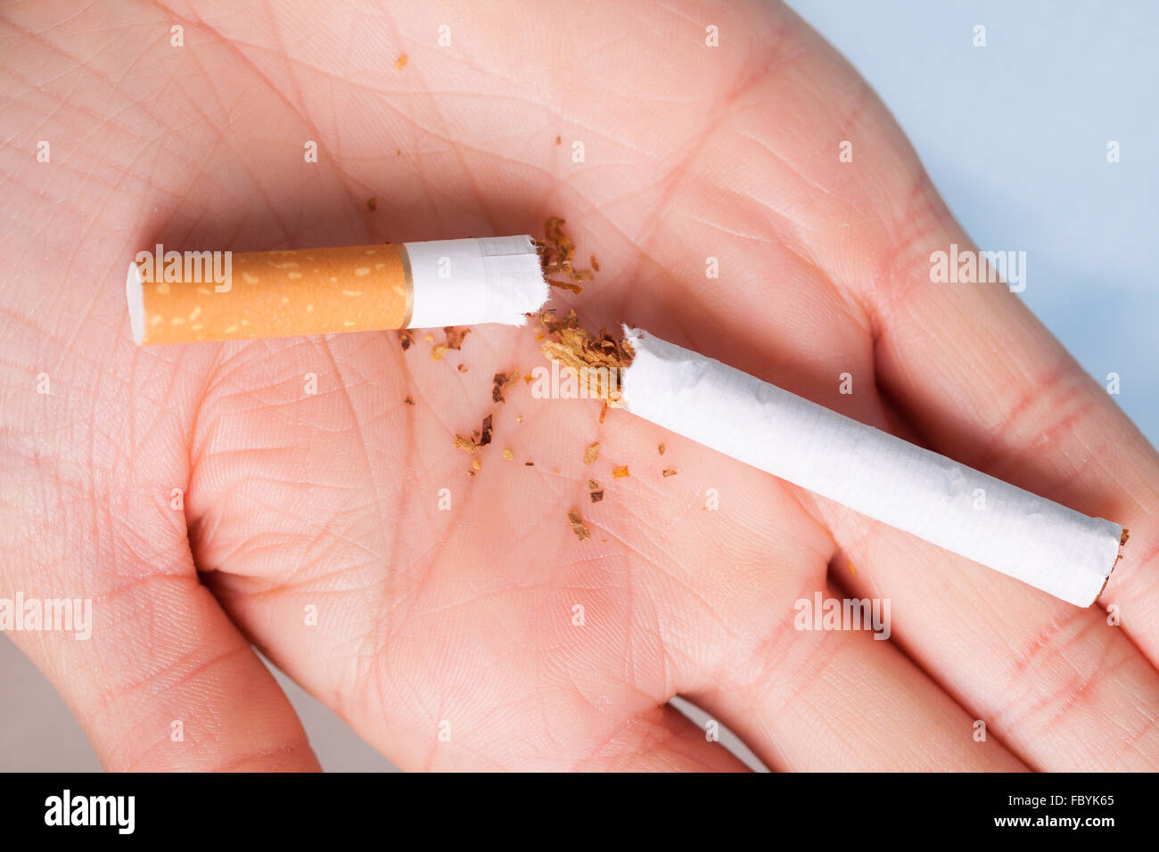 Addiction. Broken cigarette on hand. Quit smoking Stock Photo