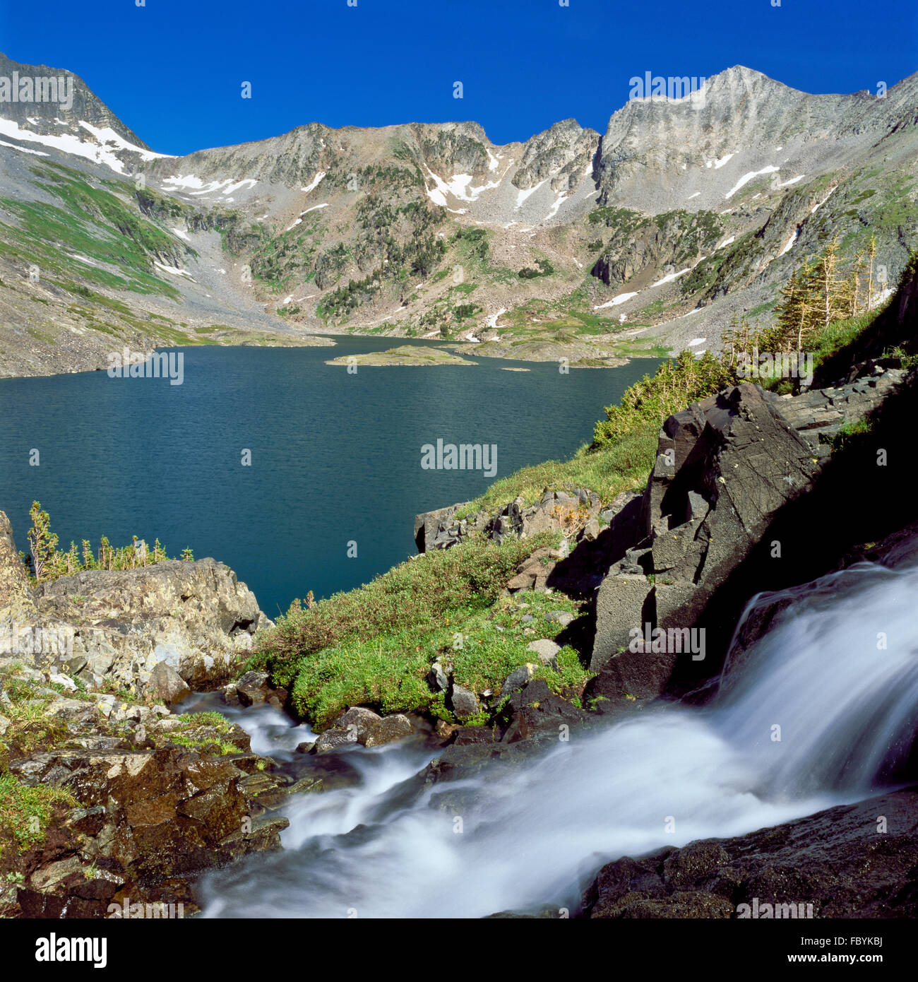 waterfall cascading to rock lake in the crazy mountains near clyde park