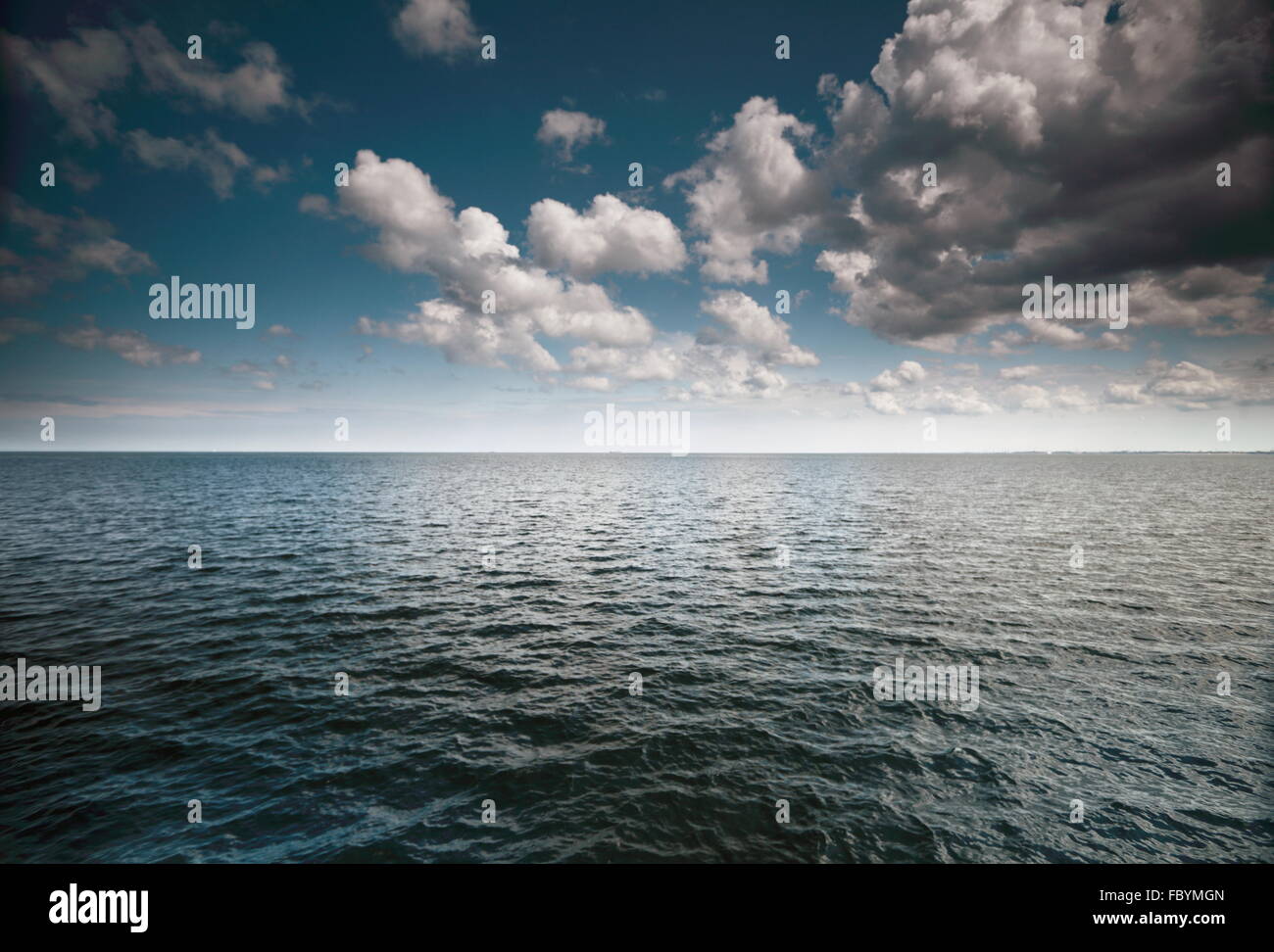 Cloudy blue sky above a surface of the sea Stock Photo - Alamy