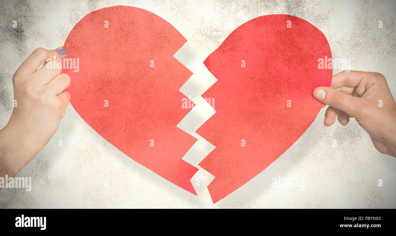 Composite image of two hands holding broken heart Stock Photo - Alamy