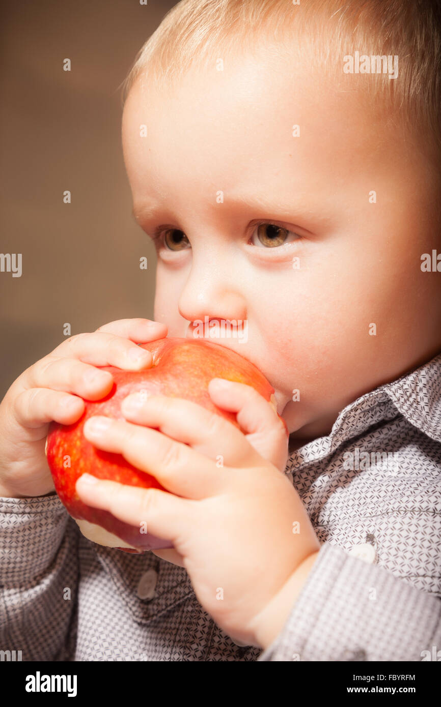Cute baby boy eating red apple fruit Stock Photo Alamy