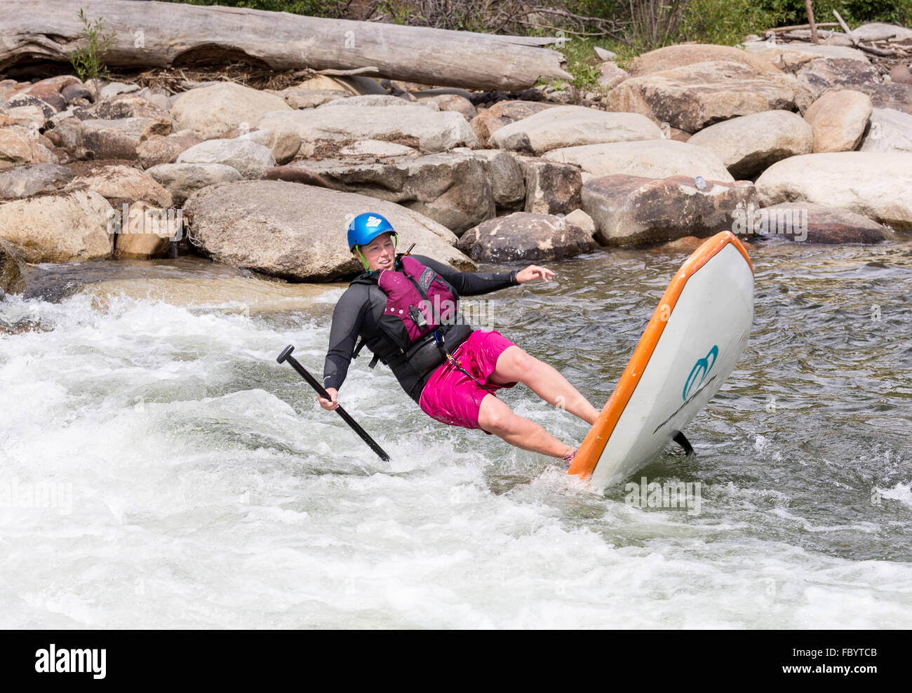 Stand up paddleboarder falling in white water Stock Photo