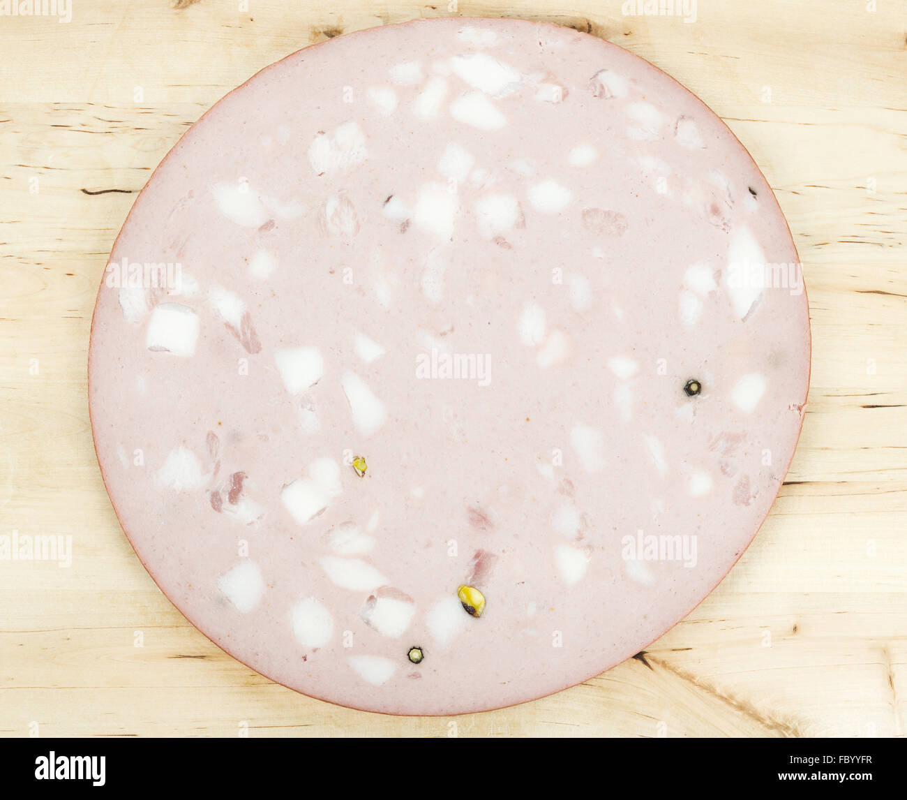Mortadella Bologna italian pork sausage or cold cut on wood background or texture close up. Mortadella Igp is a staple food prod Stock Photo