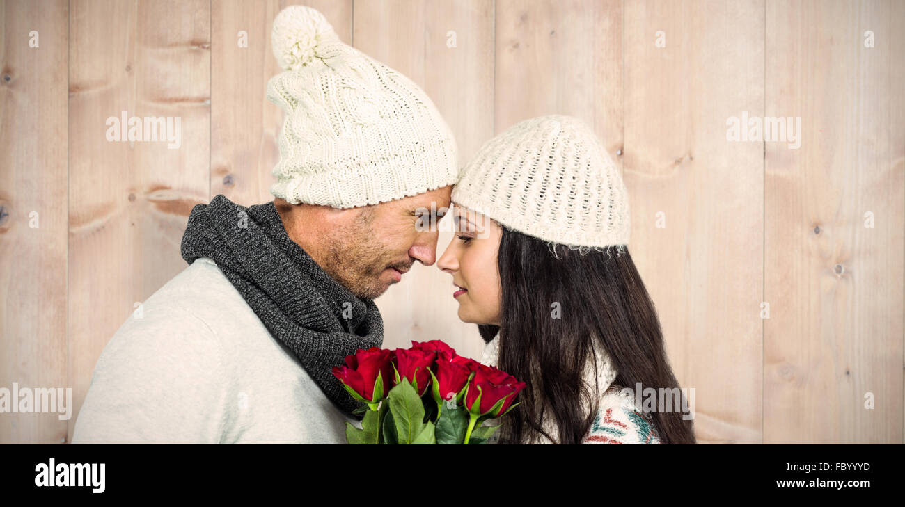 Composite image of smiling couple nosetonose holding roses bouquet
