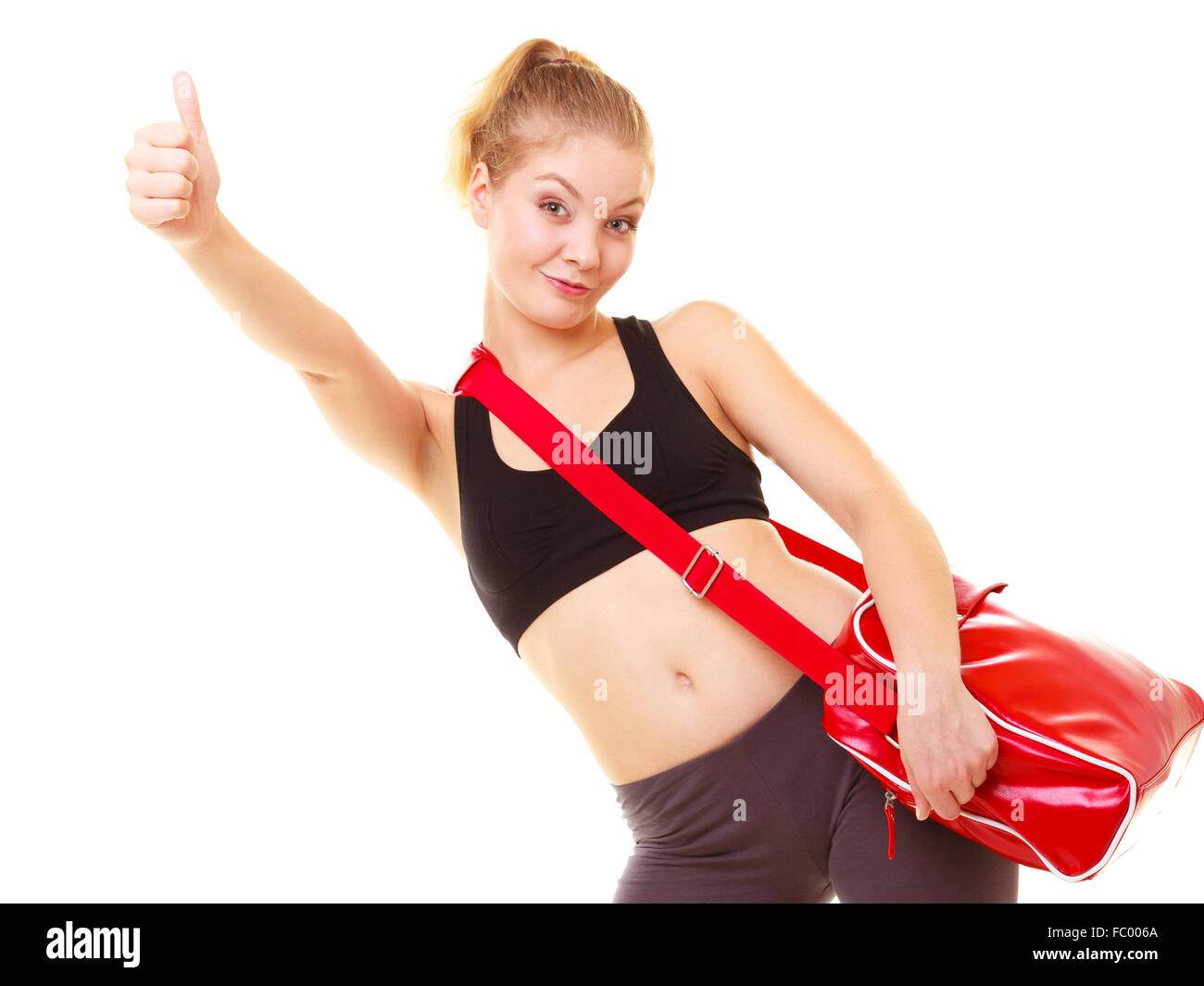 Sport. Fitness girl with gym bag showing thumb up Stock Photo