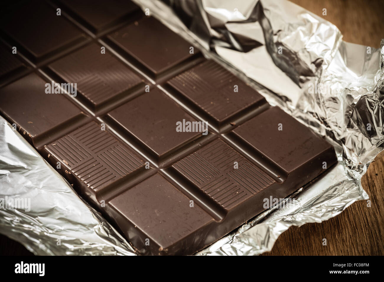 Dark chocolate bar in opened foil wrapping Stock Photo - Alamy