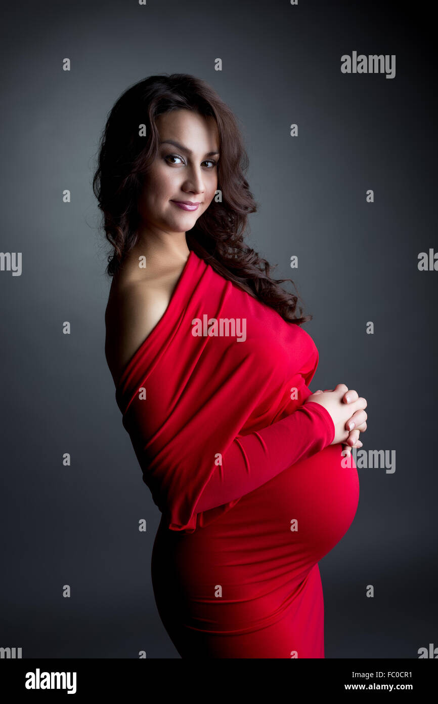 Smiling expectant mother posing at camera Stock Photo