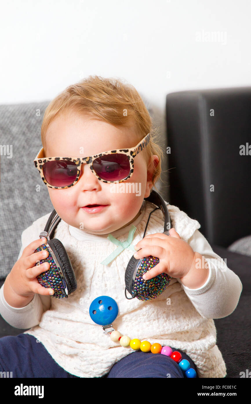 Little baby with headphones and sunglasses Stock Photo