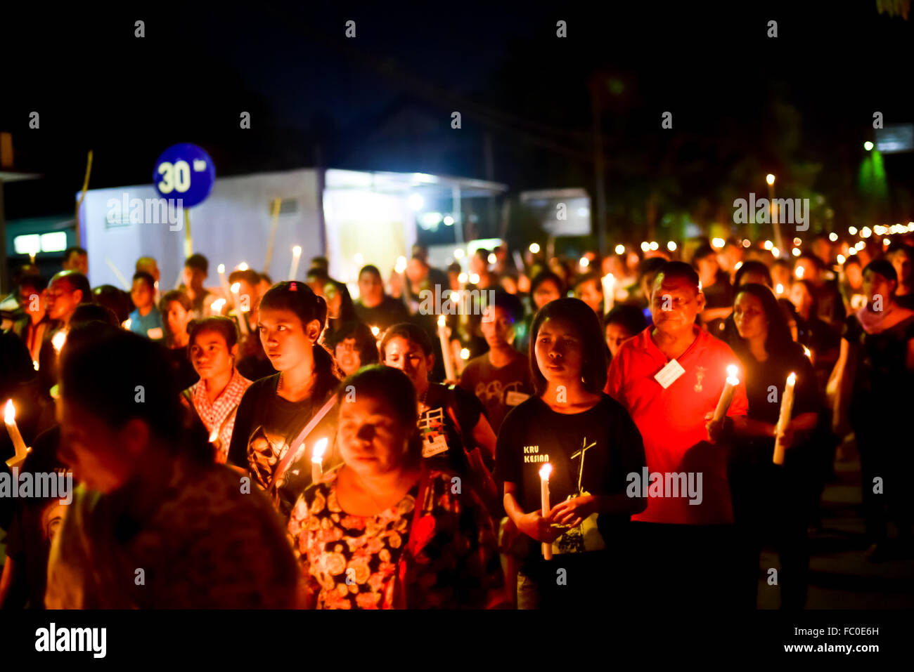 Catholic pilgrims walk together with lit candles in holy week procession in Larantuka, Indonesia. Stock Photo