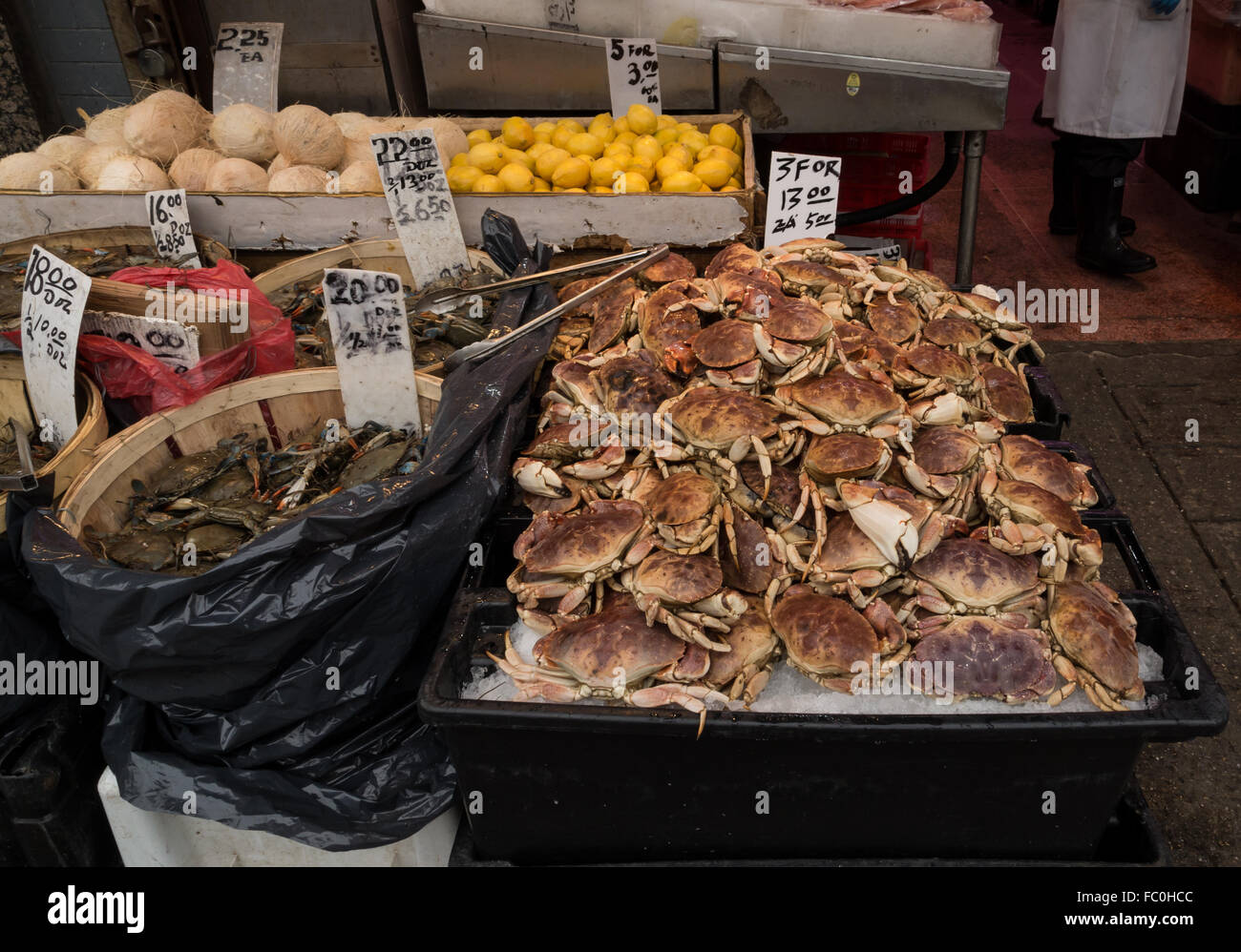 Piles of crabs and lemons for sale in a seafood and fish market shop in Chinatown, New York City. Stock Photo
