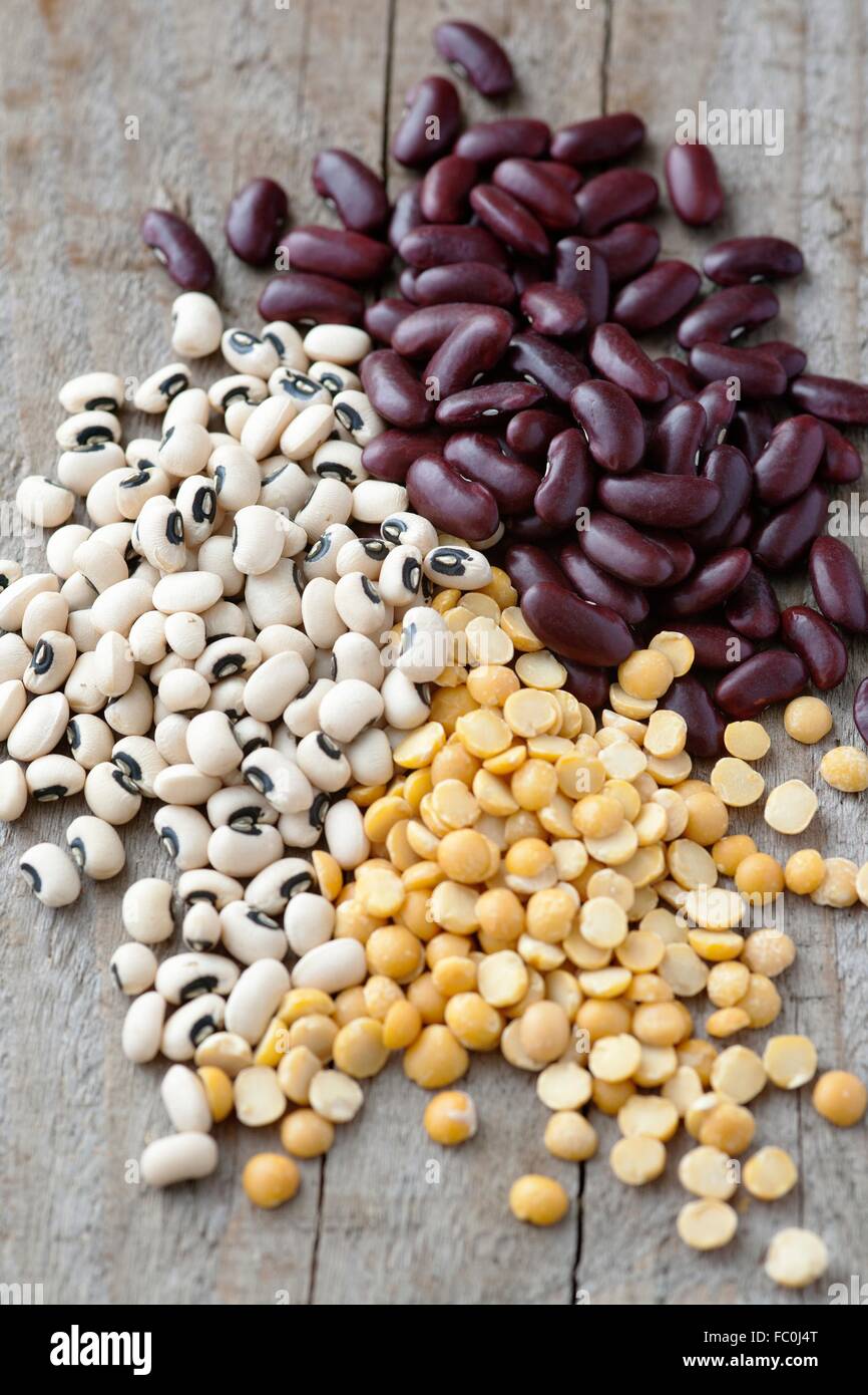 Red kidney beans, black eyed beans and yellow split lentils on a wood table Stock Photo