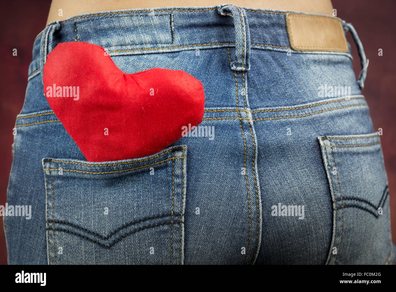 red heart in back pocket jeans of woman, valentine's concept Stock Photo