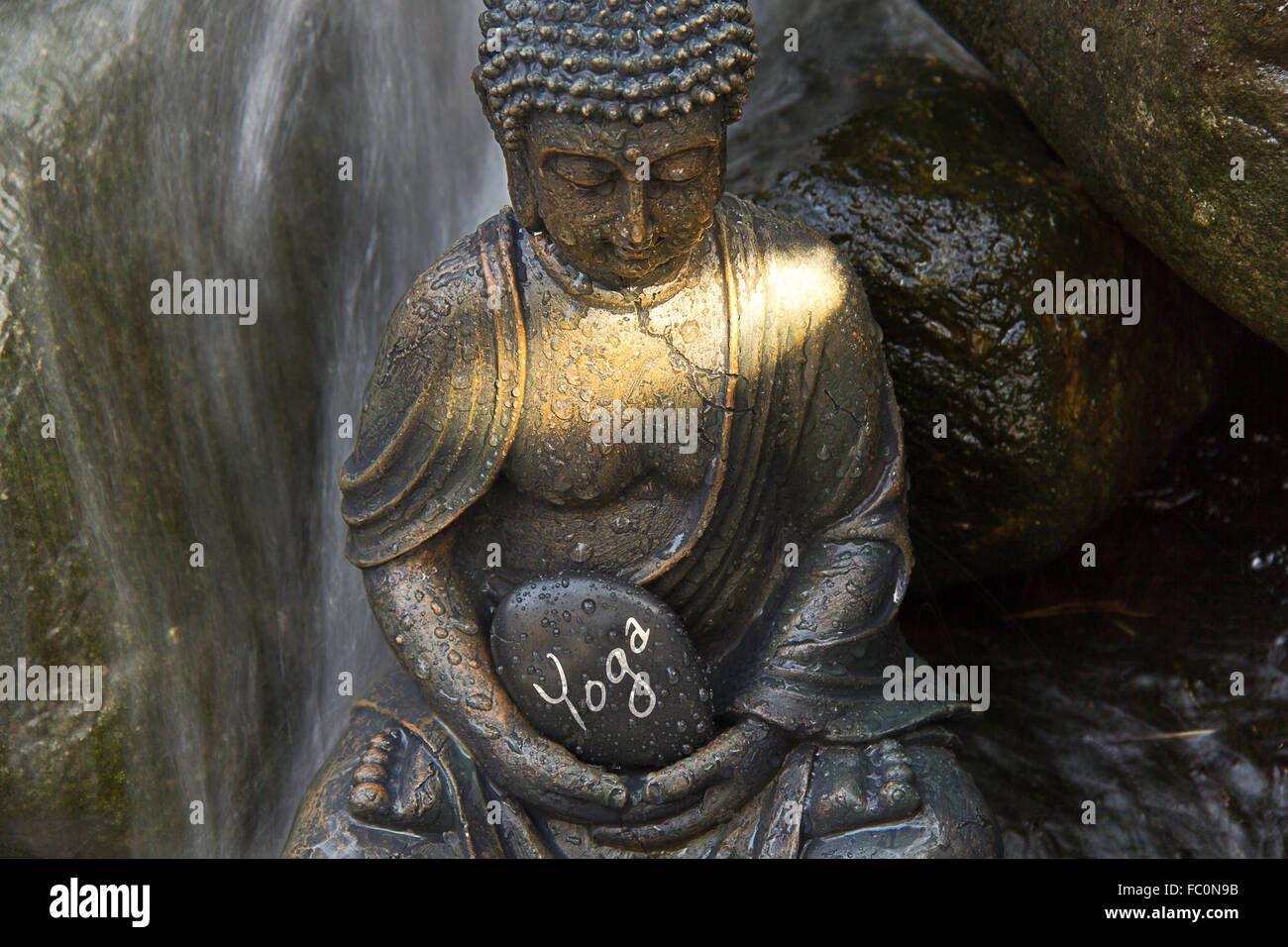 Buddha statue with the word „Yoga“ Stock Photo